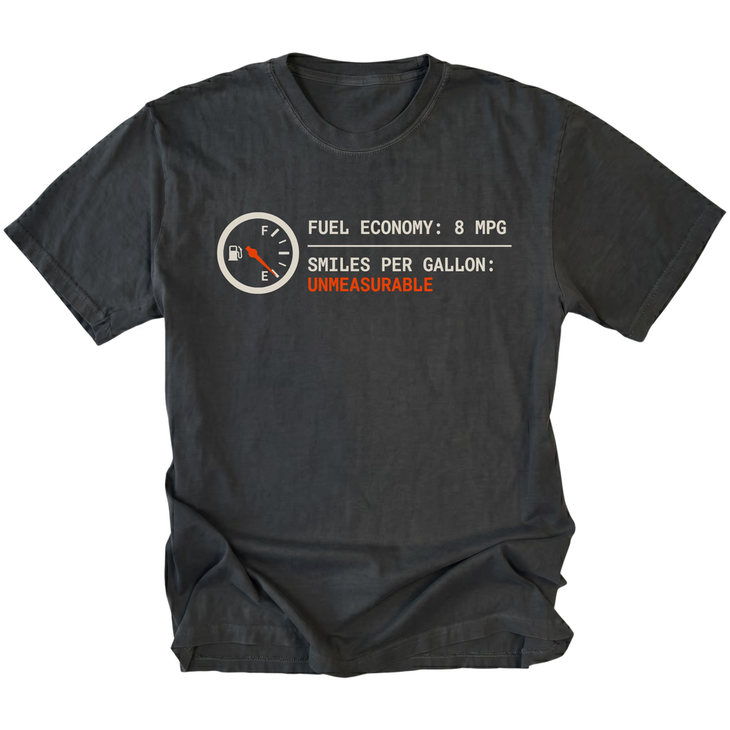 Black t-shirt featuring a fuel gauge graphic with text reading fuel economy 8 MPG and smiles per gallon unmeasurable displayed on the front.