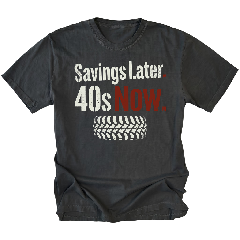 Black T-Shirt featuring Savings Later 40s Now design with large off-road tire graphic on front view by Trail Snark.