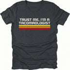 Black t-shirt with retro stripes and the phrase “Trust Me, I’m a Tacomaologist” printed on the front by Trail Snark.