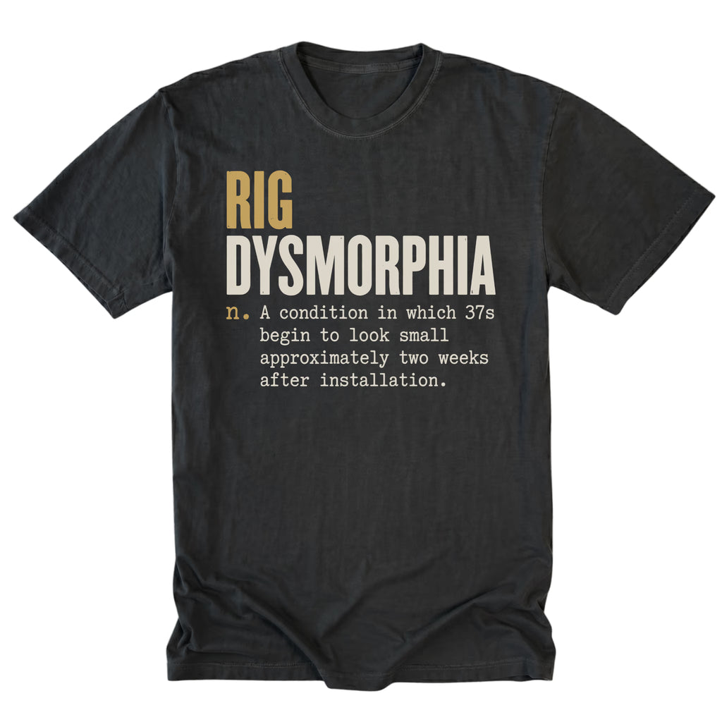 A black graphic t-shirt laid flat on a white background. The shirt features a humorous definition print that reads 'RIG DYSMORPHIA' with a noun definition underneath.