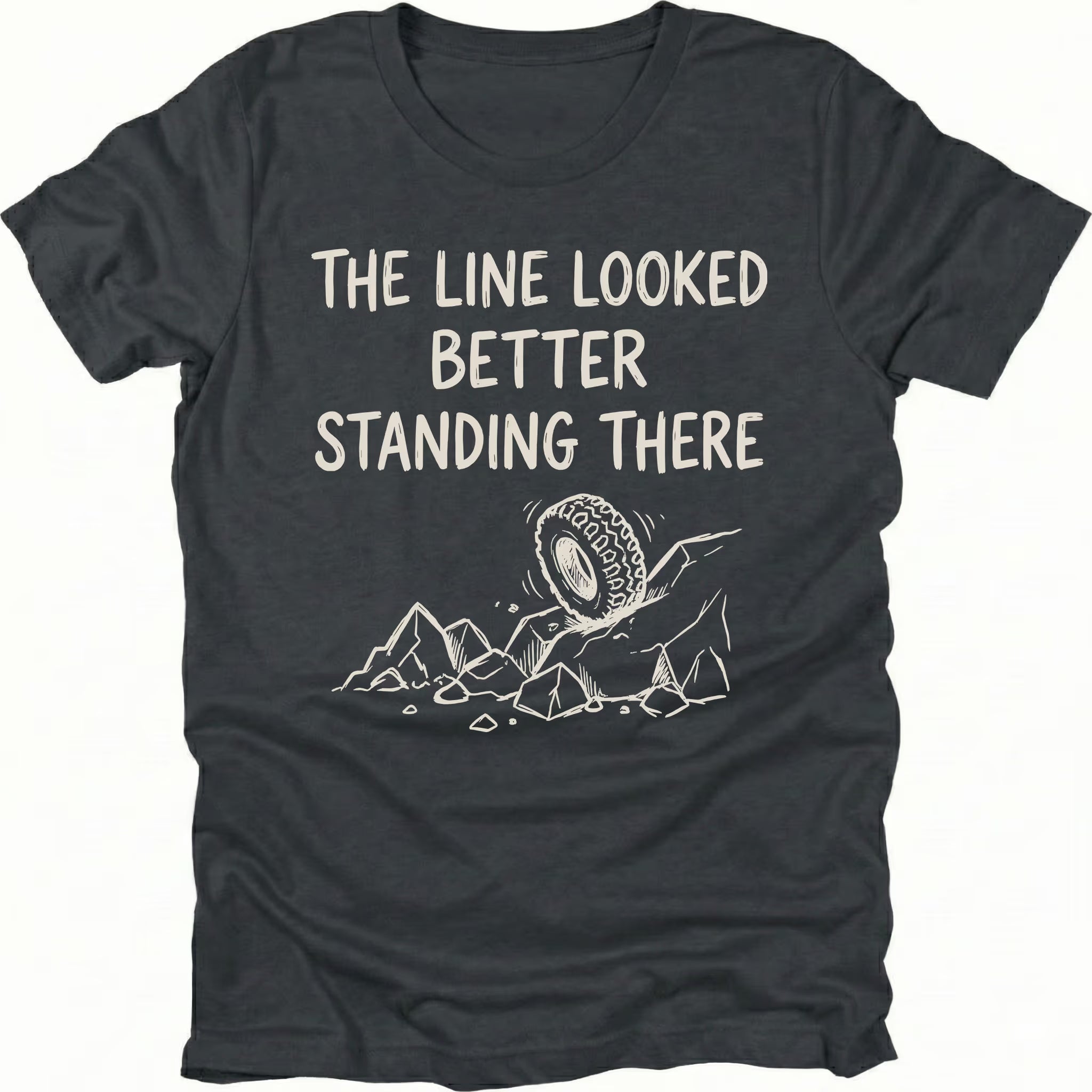 Black T-Shirt with hand-drawn tire and rocks graphic and text reading “The Line Looked Better Standing There” shown on front view by Trail Snark.
