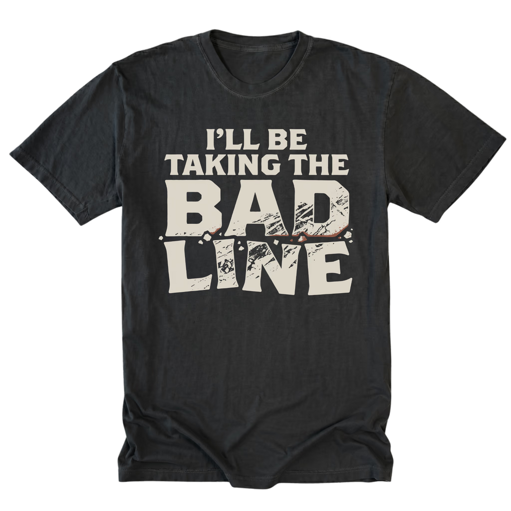 A black t-shirt with a distressed graphic print that reads 'I'LL BE TAKING THE BAD LINE' in off-white text, displayed flat against a solid white background.