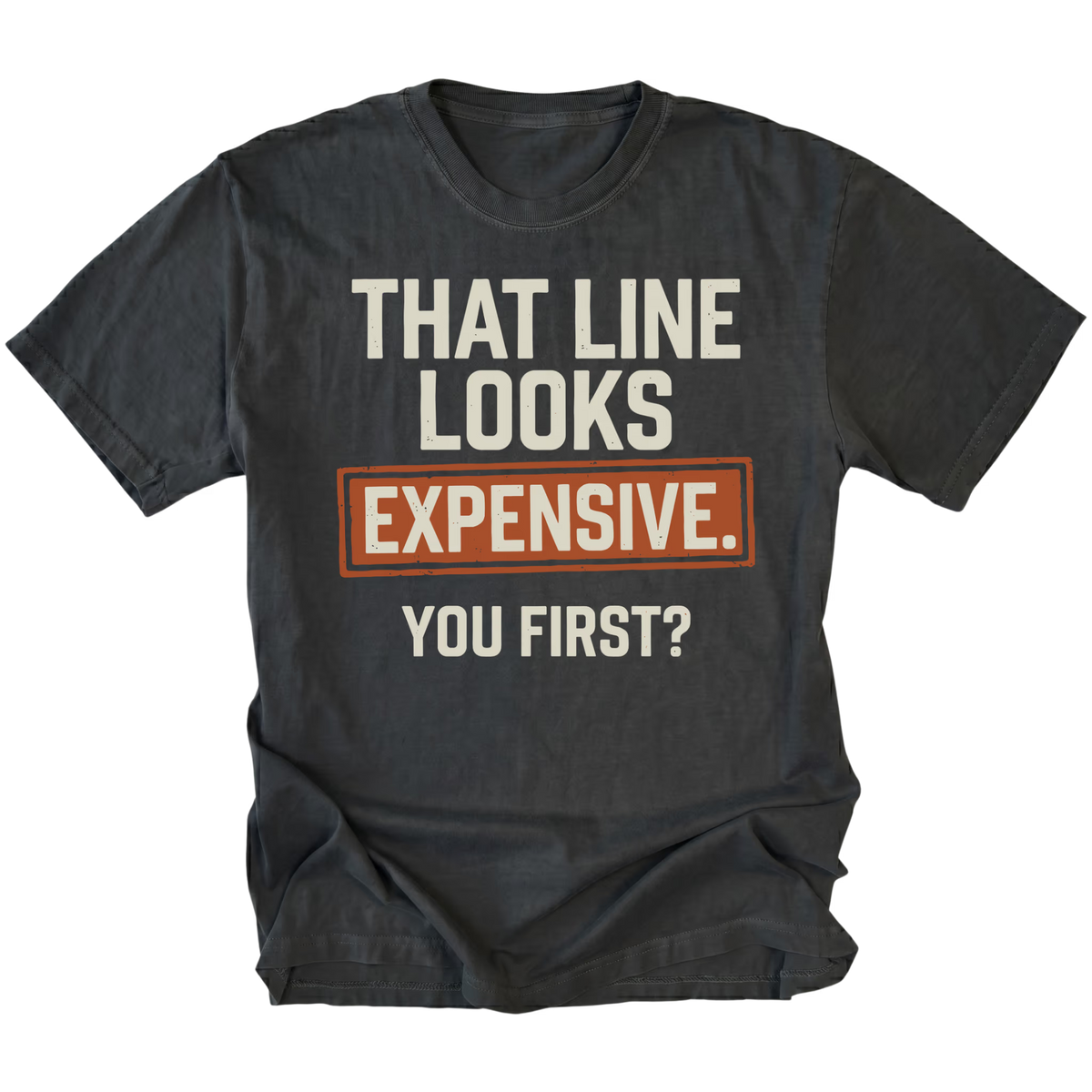 A black t-shirt featuring the text 'THAT LINE LOOKS EXPENSIVE. YOU FIRST?', on a white background.