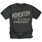 A black t-shirt with a distressed graphic print that reads 'MOMENTUM IS A VALID STRATEGY' in a light beige font, displayed against a solid white background.
