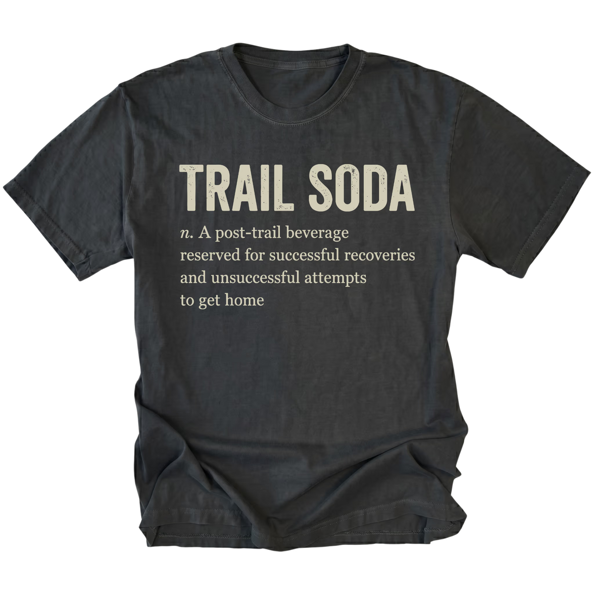 A black t-shirt with a humorous definition of 'Trail Soda' printed in beige text on the front, displayed against a solid white background.