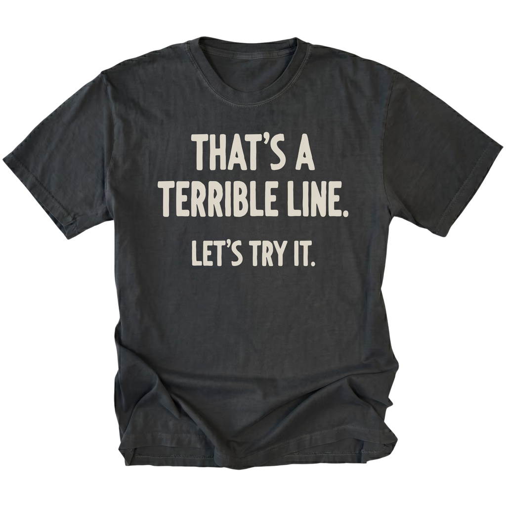 A black t-shirt featuring the text 'THAT'S A TERRIBLE LINE. LET'S TRY IT' on a white background.