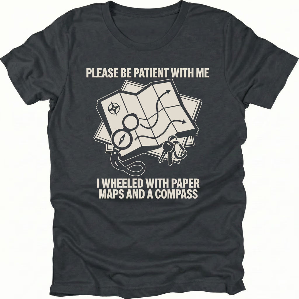 Black T-Shirt with paper map and compass graphic reading “Please Be Patient With Me I Wheeled With Paper Maps And A Compass” shown on front view by Trail Snark.