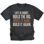 A black short-sleeve t-shirt with a distressed white and orange text graphic on the front reading 'LIFE IS SHORT. BUILD THE RIG. WHEEL IT HARD. BUILD IT AGAIN.'