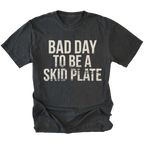 Black t-shirt featuring bold bad day to be a skid plate text graphic shown from the front by Trail Snark.