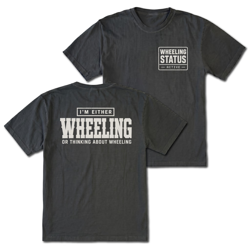 Black T-shirt with I'm Either Wheeling Or Thinking About Wheeling back design and Wheeling Status front chest print by Trail Snark.