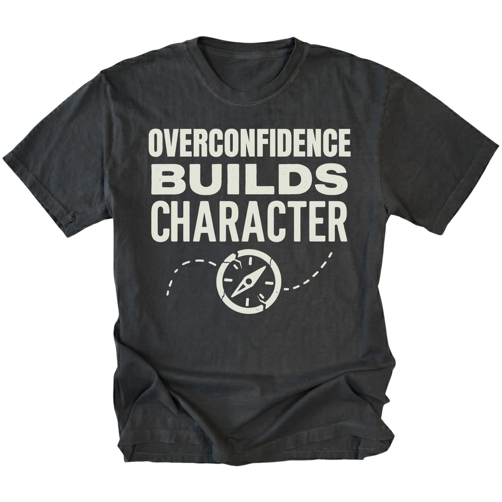 Black T-Shirt with “Overconfidence Builds Character” text and compass graphic shown on front view by Trail Snark.