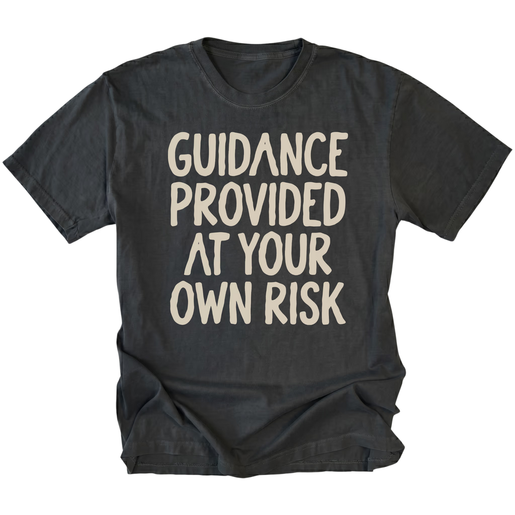 A black t-shirt featuring the text 'GUIDANCE PROVIDED AT YOUR OWN RISK'.