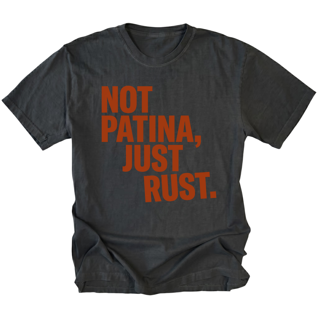 Black t-shirt with bold rust-colored text reading Not Patina, Just Rust on the front.
