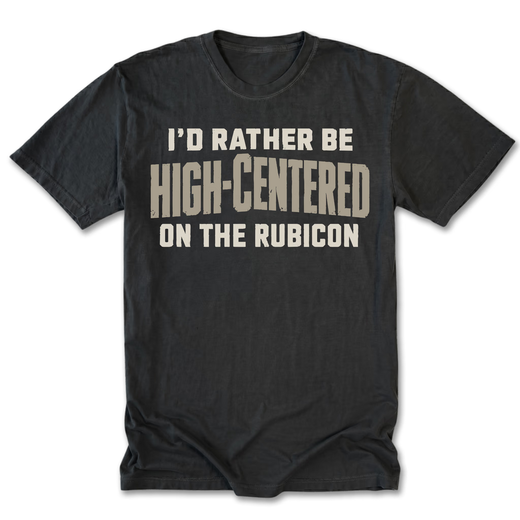 A black t-shirt with a distressed beige graphic text that reads 'I'D RATHER BE HIGH-CENTERED ON THE RUBICON'.