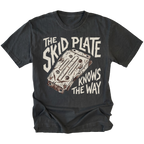 A black graphic t-shirt featuring a distressed cream-colored print of a metal water cooler plate with the text 'THE SKID PLATE KNOWS THE WAY'. The t-shirt is displayed flat against a clean white background.