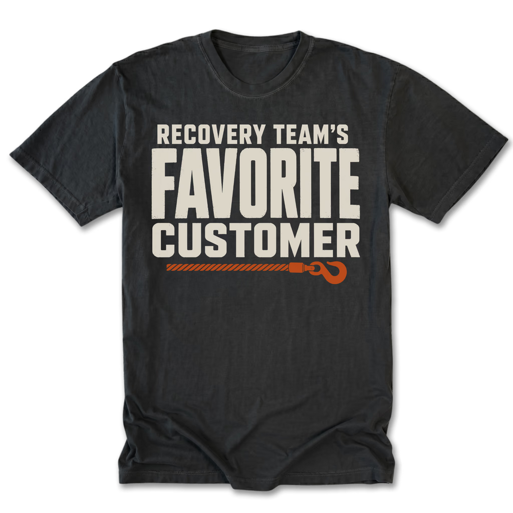 A black t-shirt with a graphic print that reads 'RECOVERY TEAM'S FAVORITE CUSTOMER' in off-white block letters, with an orange rope and hook illustration underneath, displayed on a clean white background.