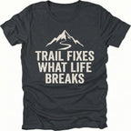 Black t-shirt with the phrase “Trail Fixes What Life Breaks” beneath a mountain and winding trail graphic printed on the front.