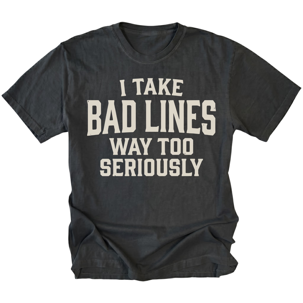 A black t-shirt with a distressed cream-colored text graphic that reads 'I TAKE BAD LINES WAY TOO SERIOUSLY' on a solid white background.
