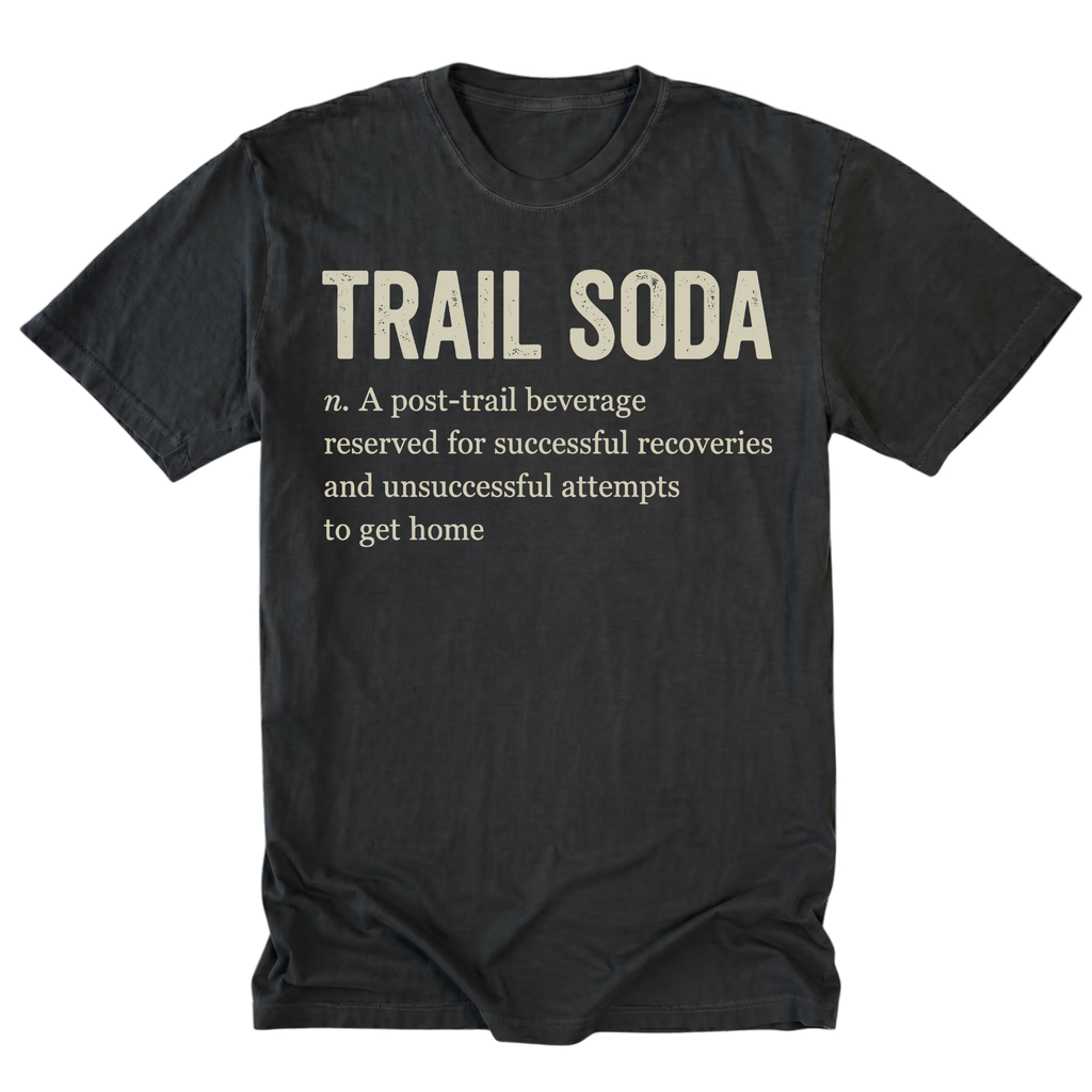 A black crewneck t-shirt with a humorous dictionary-style definition printed on the front reading 'TRAIL SODA' and a dictionary definition underneath, shown against a plain white background.
