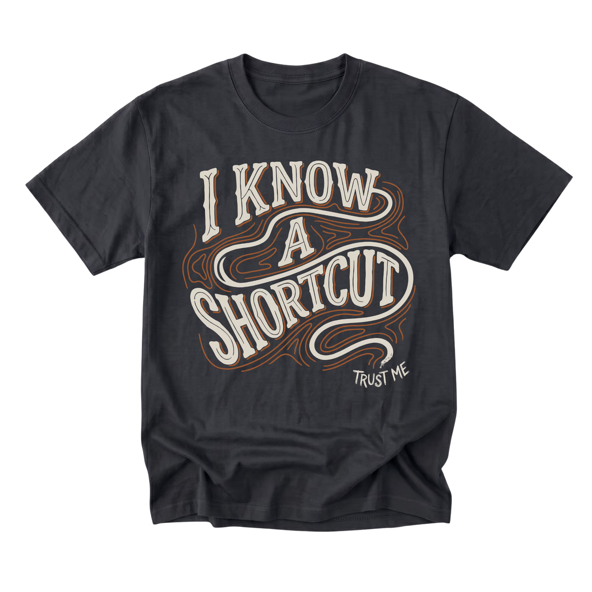 A black graphic t-shirt featuring the phrase 'I KNOW A SHORTCUT' in a retro, wavy cream and brown font, with 'TRUST ME' printed in small white text below it, displayed on a clean white background.