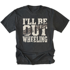 A black t-shirt with a distressed graphic on the front that reads 'I'LL BE OUT WHEELING' in cream-colored lettering, featuring tire tracks inside the letters 'O' and 'U'.