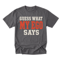 A charcoal gray crewneck t-shirt with a graphic text print reading 'GUESS WHAT MY EGO SAYS' in distressed cream and orange lettering, displayed on a solid white background.