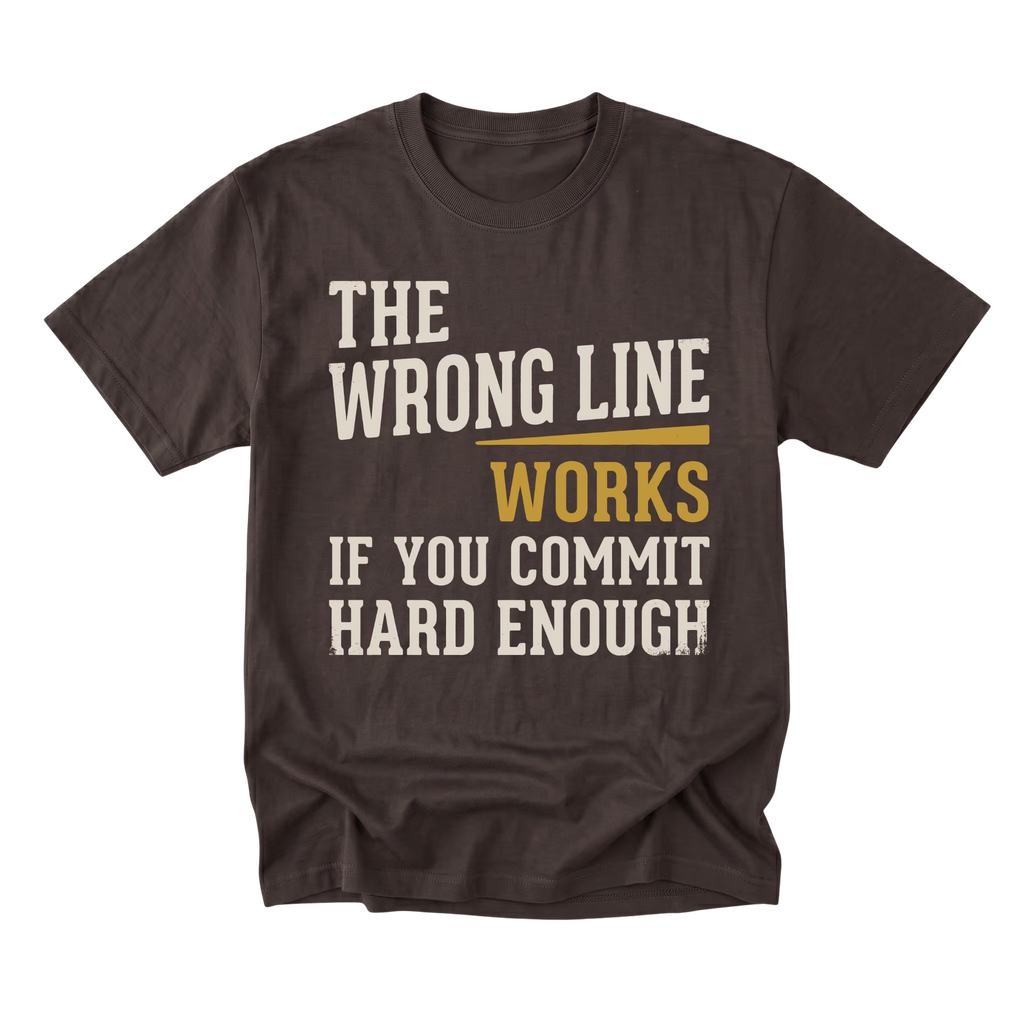 A dark brown short-sleeve t-shirt with a distressed graphic print on the front. The text reads 'THE WRONG LINE WORKS IF YOU COMMIT HARD ENOUGH' in cream and mustard yellow lettering, displayed against a solid white background.