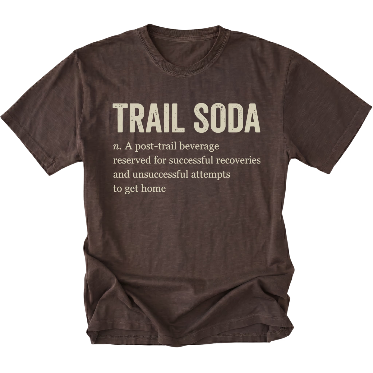 A dark brown short-sleeve t-shirt with a distressed texture, featuring a humorous definition of 'Trail Soda' printed in beige text on the front.
