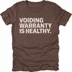 Espresso t-shirt with bold text reading “Voiding Warranty Is Healthy” printed on the front.