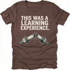 Espresso t-shirt with text reading “This Was a Learning Experience” above an illustration of a broken axle or CV joint, shown on the front.