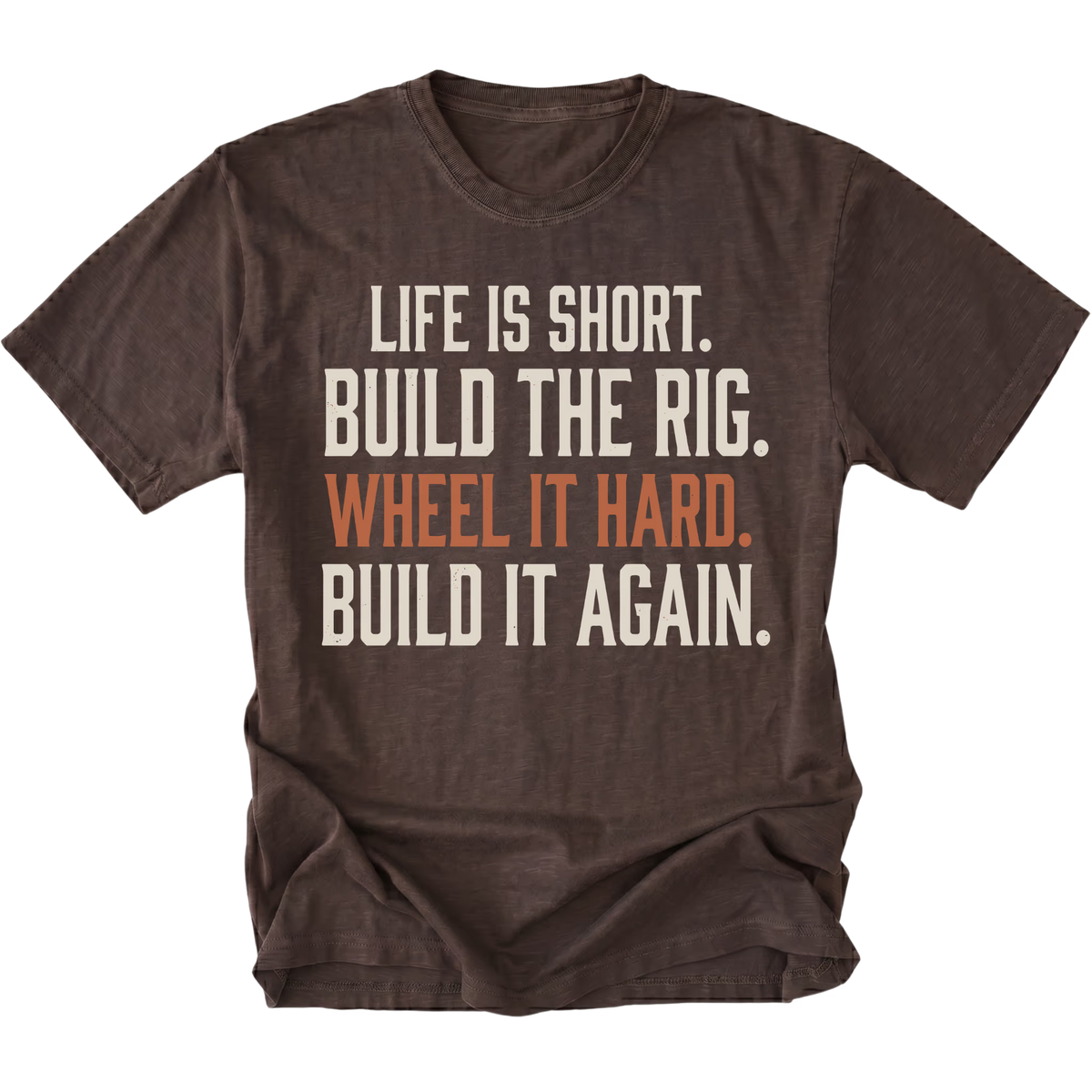 A dark brown short-sleeve t-shirt with a distressed white and orange text graphic on the front reading 'LIFE IS SHORT. BUILD THE RIG. WHEEL IT HARD. BUILD IT AGAIN.'