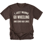 A dark brown t-shirt with distressed cream-colored text that reads 'I JUST WANNA GO WHEELING AND SEND BAD LINES' on a solid white background.