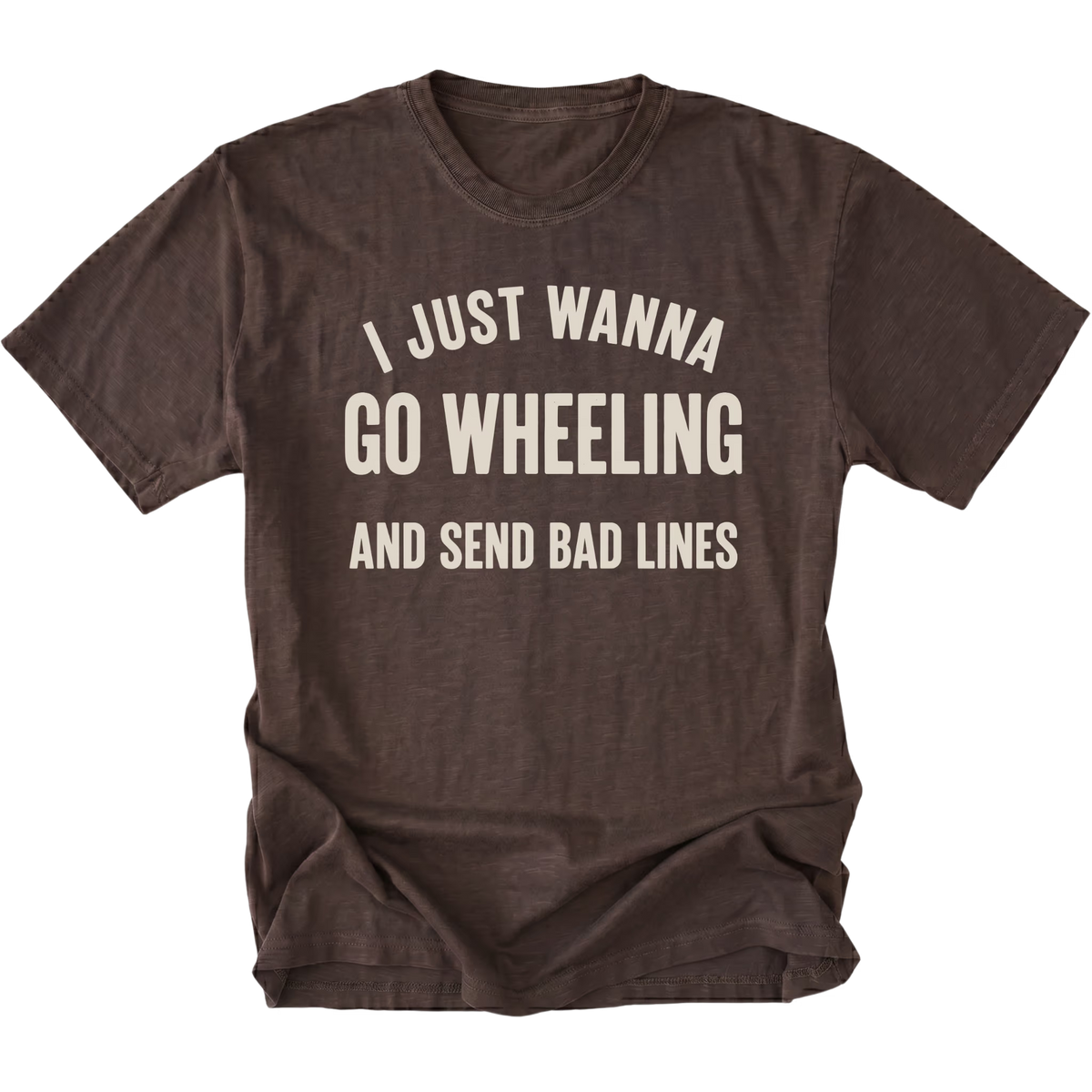 A dark brown t-shirt with distressed cream-colored text that reads 'I JUST WANNA GO WHEELING AND SEND BAD LINES' on a solid white background.