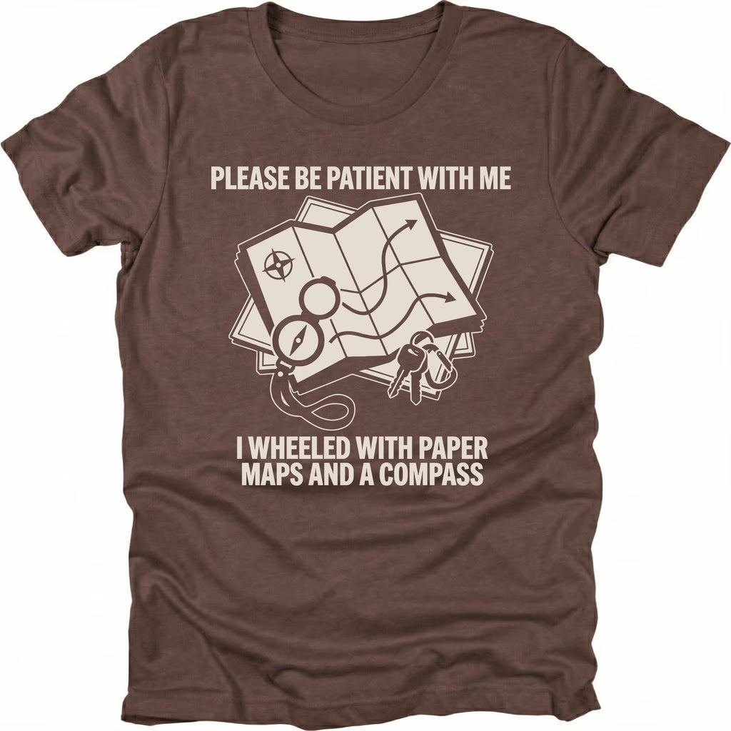 Espresso T-Shirt with paper map and compass graphic reading “Please Be Patient With Me I Wheeled With Paper Maps And A Compass” shown on front view by Trail Snark.