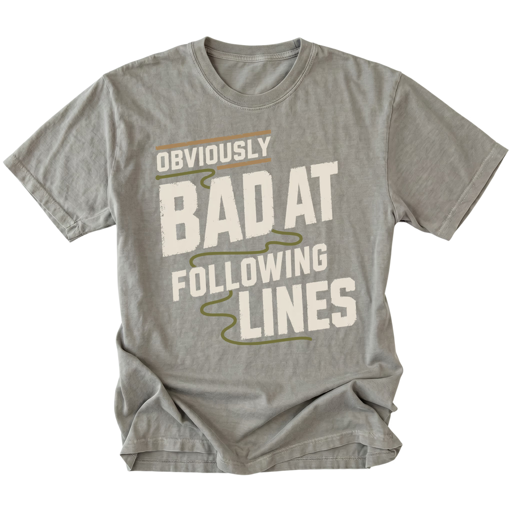 A gray short-sleeve t-shirt with a graphic print that reads 'OBVIOUSLY BAD AT FOLLOWING LINES' in distressed off-white lettering with olive green and tan accent lines, shown on a plain white background.