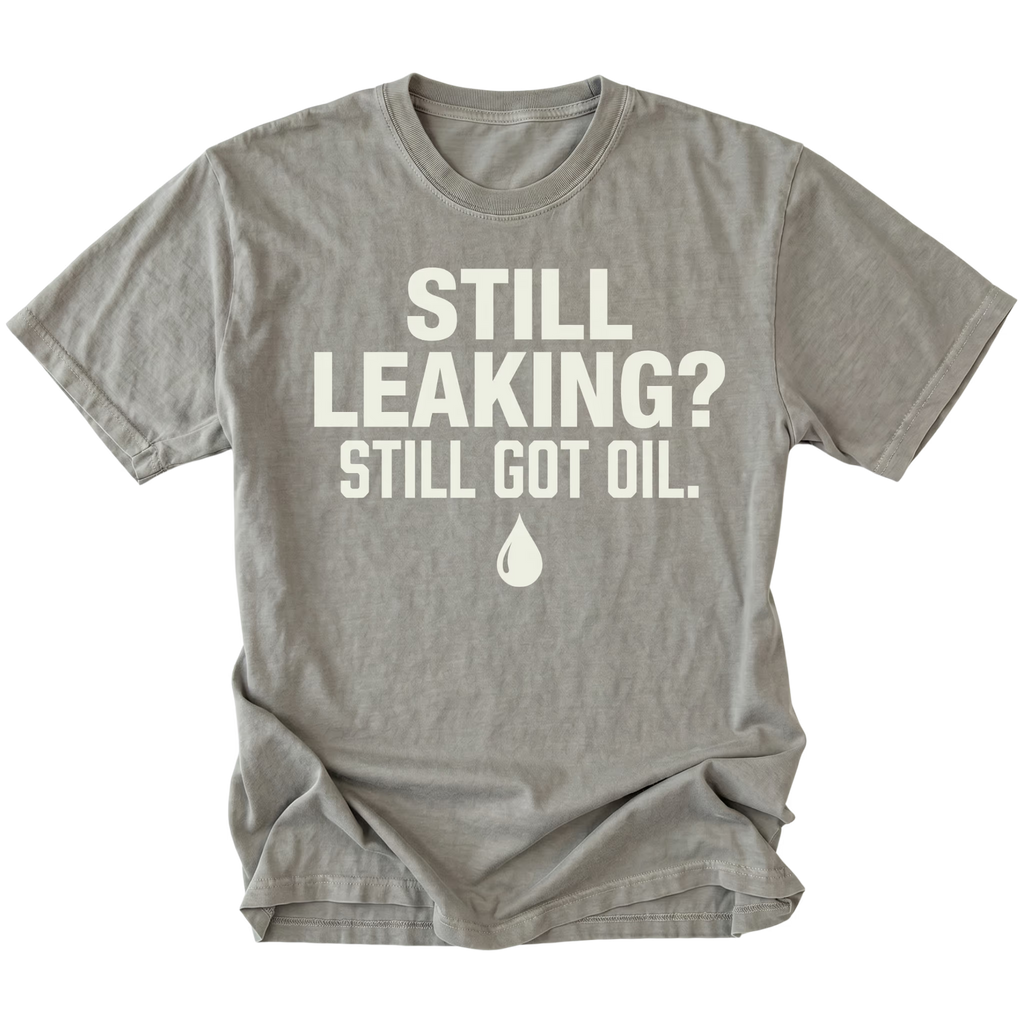 Grey T-Shirt featuring the Still Leaking? Still Got Oil. design with an oil drop graphic on the front view by Trail Snark.