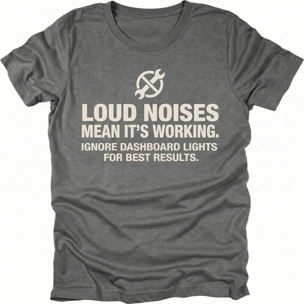 Grey t-shirt with wrench icon and text reading Loud Noises Mean It’s Working Ignore Dashboard Lights for Best Results, front view by Trail Snark.