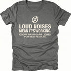 Grey t-shirt with wrench icon and text reading Loud Noises Mean It’s Working Ignore Dashboard Lights for Best Results, front view by Trail Snark.