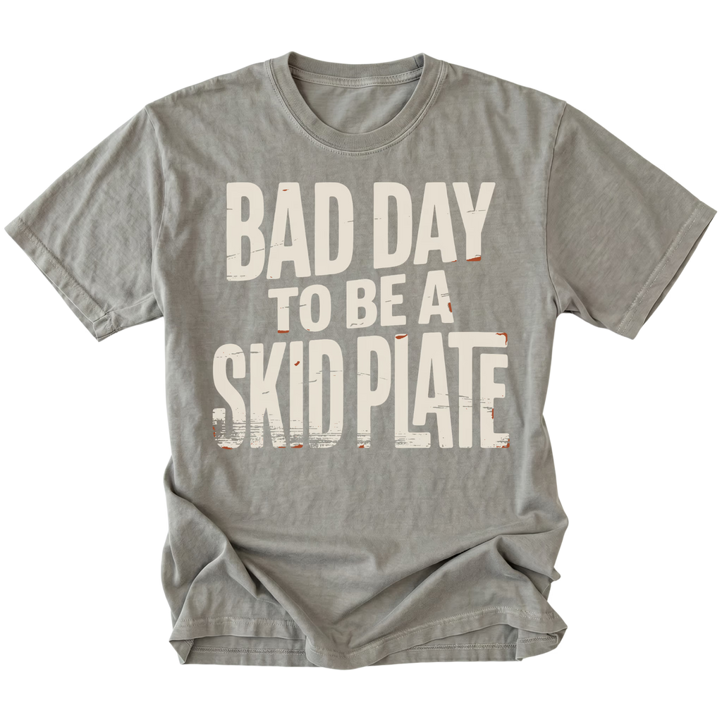 A gray short-sleeve t-shirt with a distressed white graphic text that reads 'BAD DAY TO BE A SKID PLATE' on the front, displayed against a solid white background.