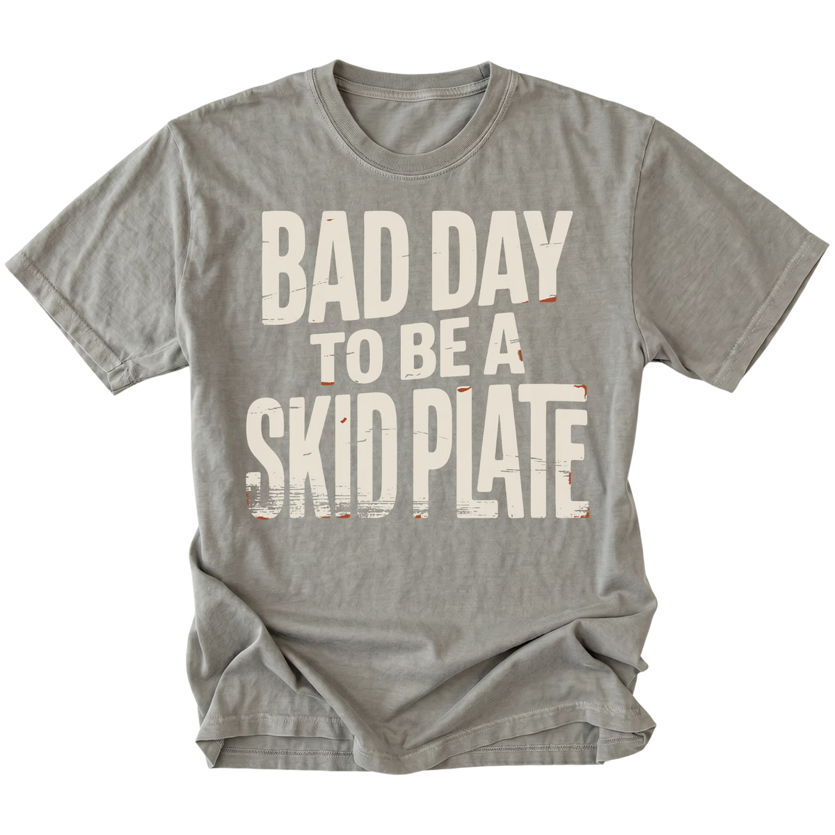 A gray short-sleeve t-shirt with a distressed white graphic text that reads 'BAD DAY TO BE A SKID PLATE' on the front, displayed against a solid white background.