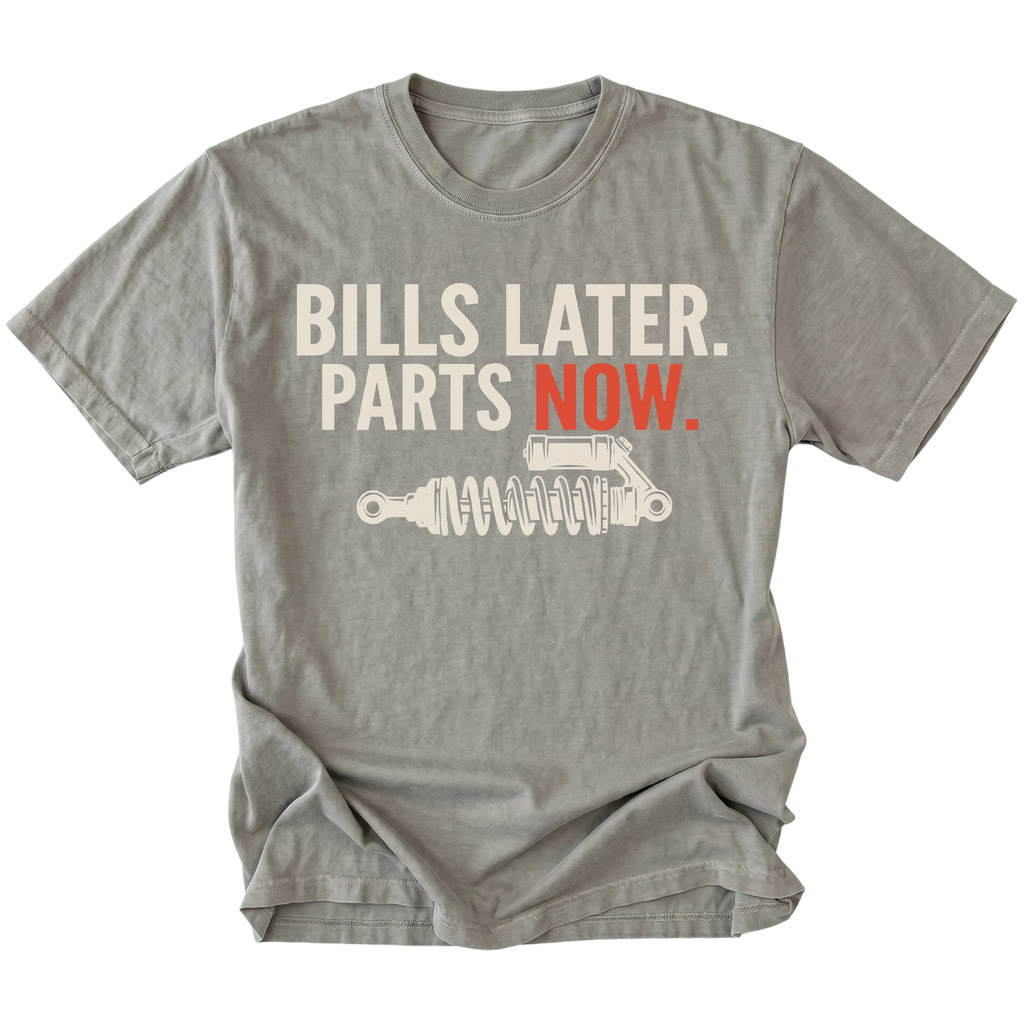 Grey t-shirt featuring Bills Later Parts Now design with suspension coilover graphic on front view by Trail Snark.
