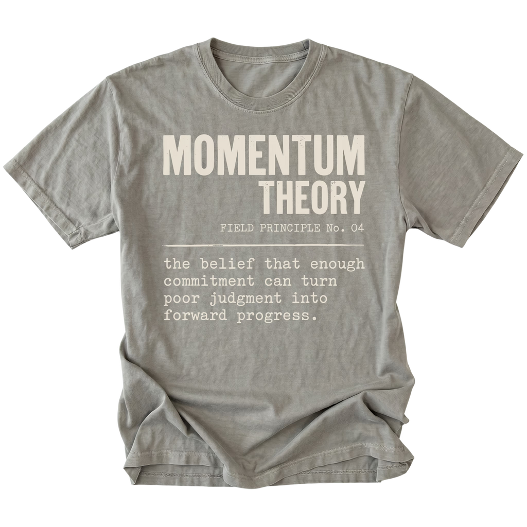 A gray crewneck t-shirt with a humorous graphic print styled like a dictionary definition for 'Momentum Theory'. The print features the text 'MOMENTUM THEORY' in bold capital letters, followed by 'FIELD PRINCIPLE No.