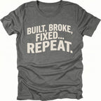 Grey t-shirt featuring built broke fixed repeat bold text graphic shown from the front by Trail Snark.