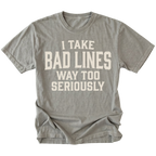 A gray short-sleeve t-shirt with a distressed cream-colored text graphic that reads 'I TAKE BAD LINES WAY TOO SERIOUSLY' on the front, displayed against a solid white background.