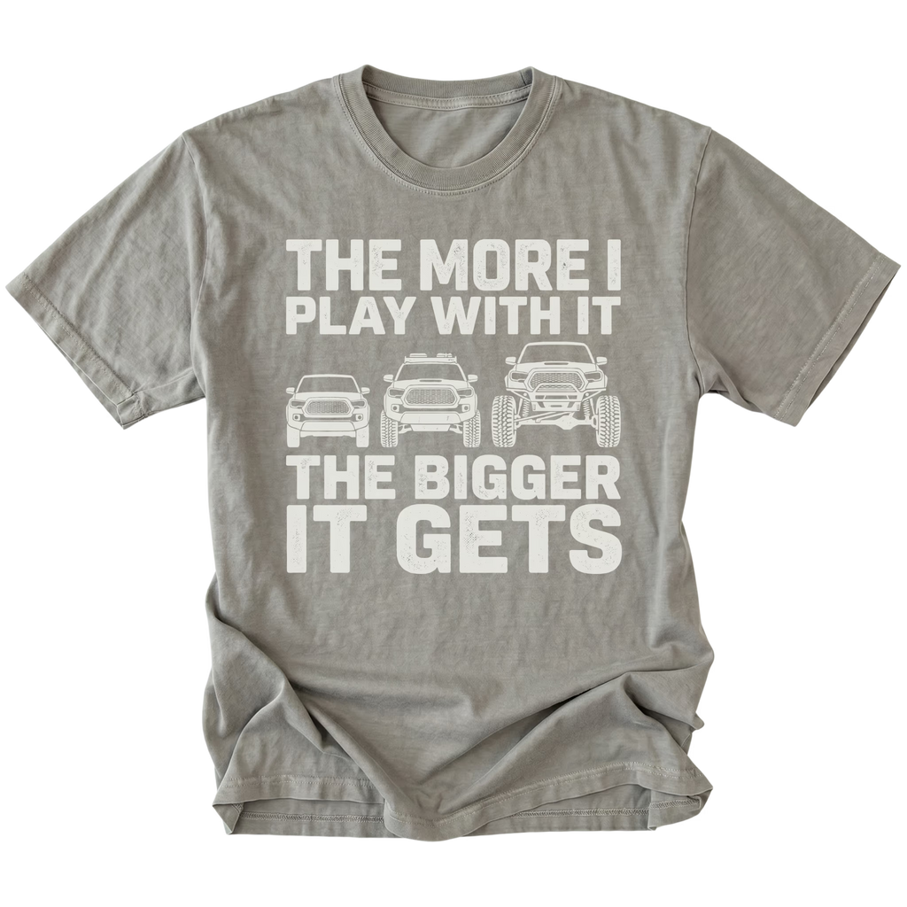 Grey T-Shirt featuring The More I Play With It The Bigger It Gets design with three progressively lifted trucks shown on the front view by Trail Snark.