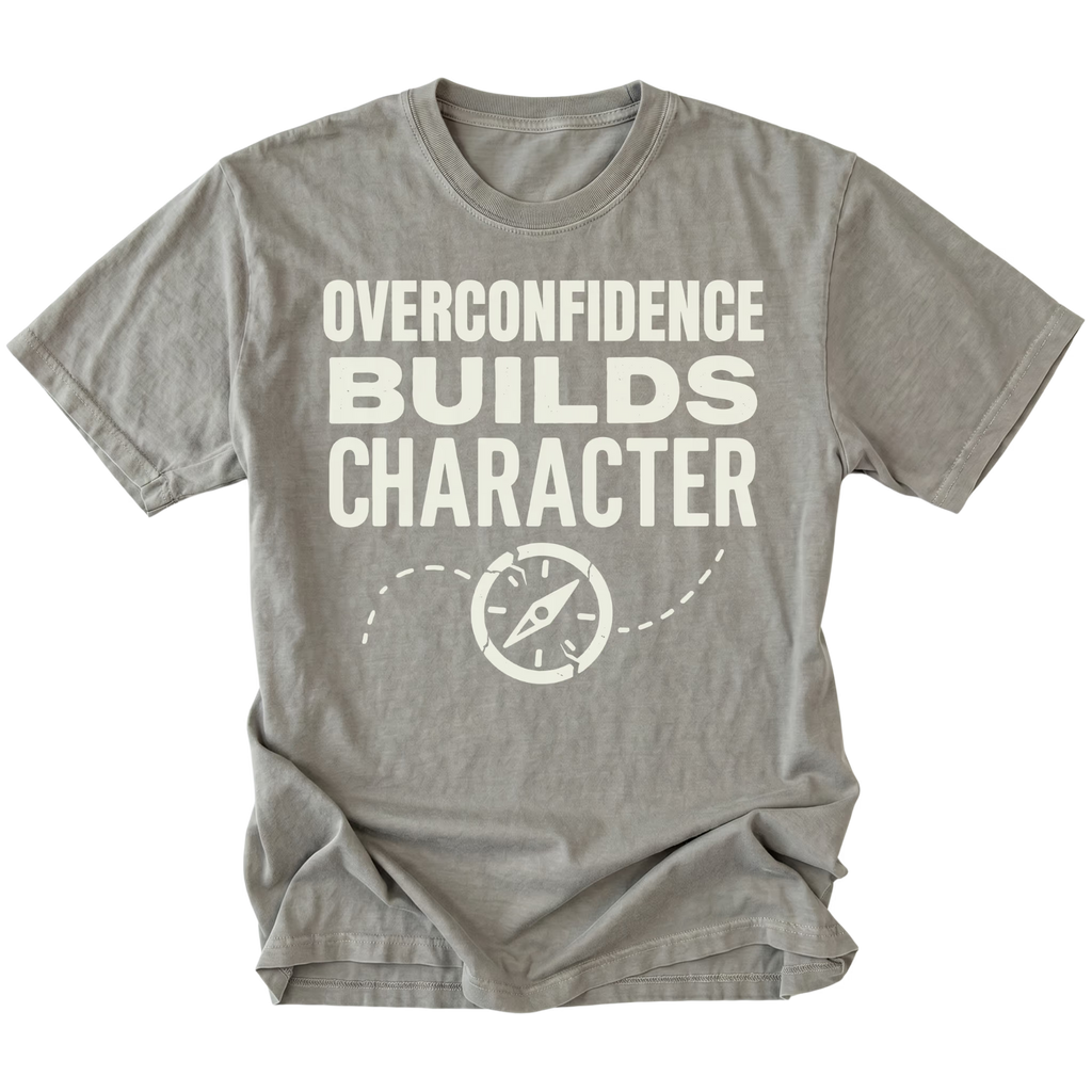Grey T-Shirt with “Overconfidence Builds Character” text and compass graphic shown on front view by Trail Snark.