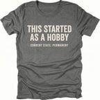 Grey t-shirt with text reading “This Started As a Hobby – Current State: Permanent” displayed on the front.