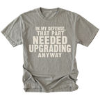 Grey t-shirt featuring the Needed Upgrading design on the front by Trail Snark.