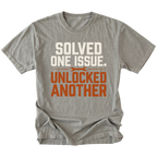 Grey T-Shirt with the Solved One Issue. Unlocked Another design shown in a front view by Trail Snark.