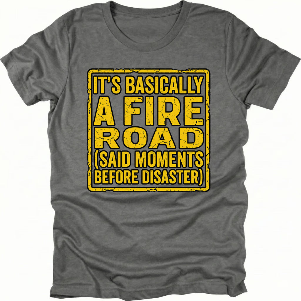 Grey t-shirt with yellow warning-style text reading Its Basically A Fire Road Said Moments Before Disaster, front view by Trail Snark.
